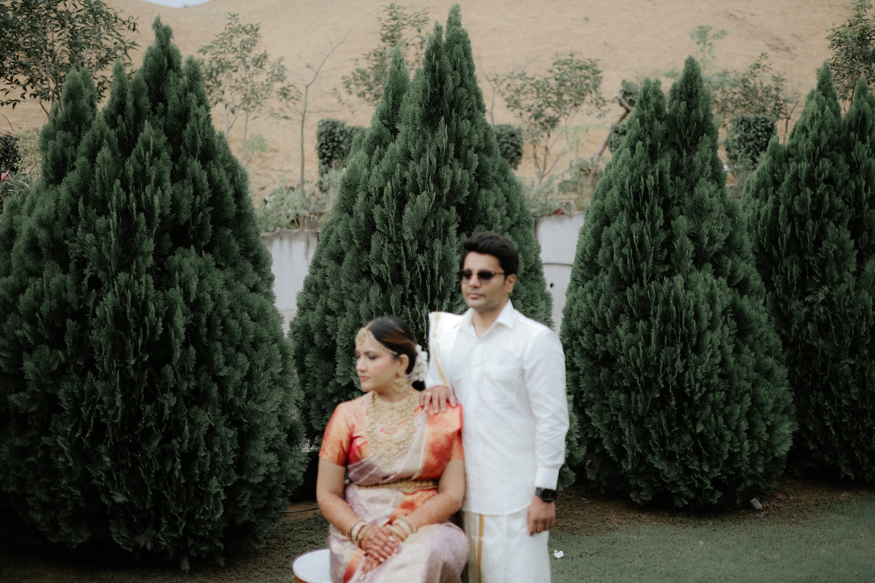 Bride and groom posing in a garden