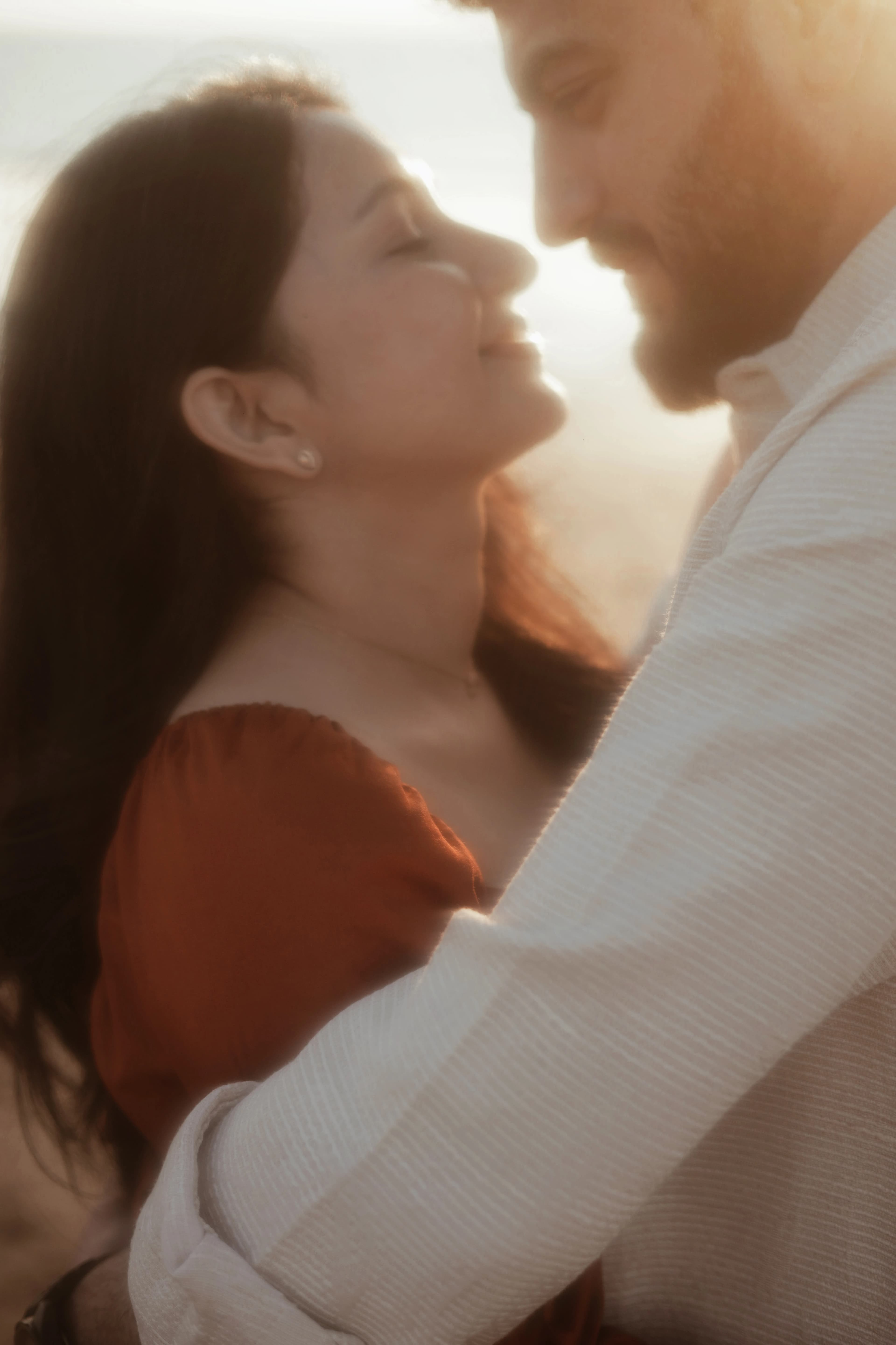 Couple embracing nose to nose in warm sunset light
