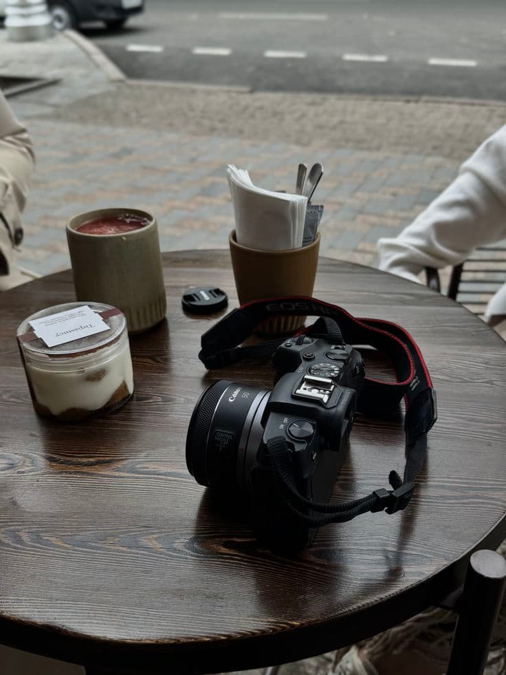 Camera resting on a café table beside coffee cups